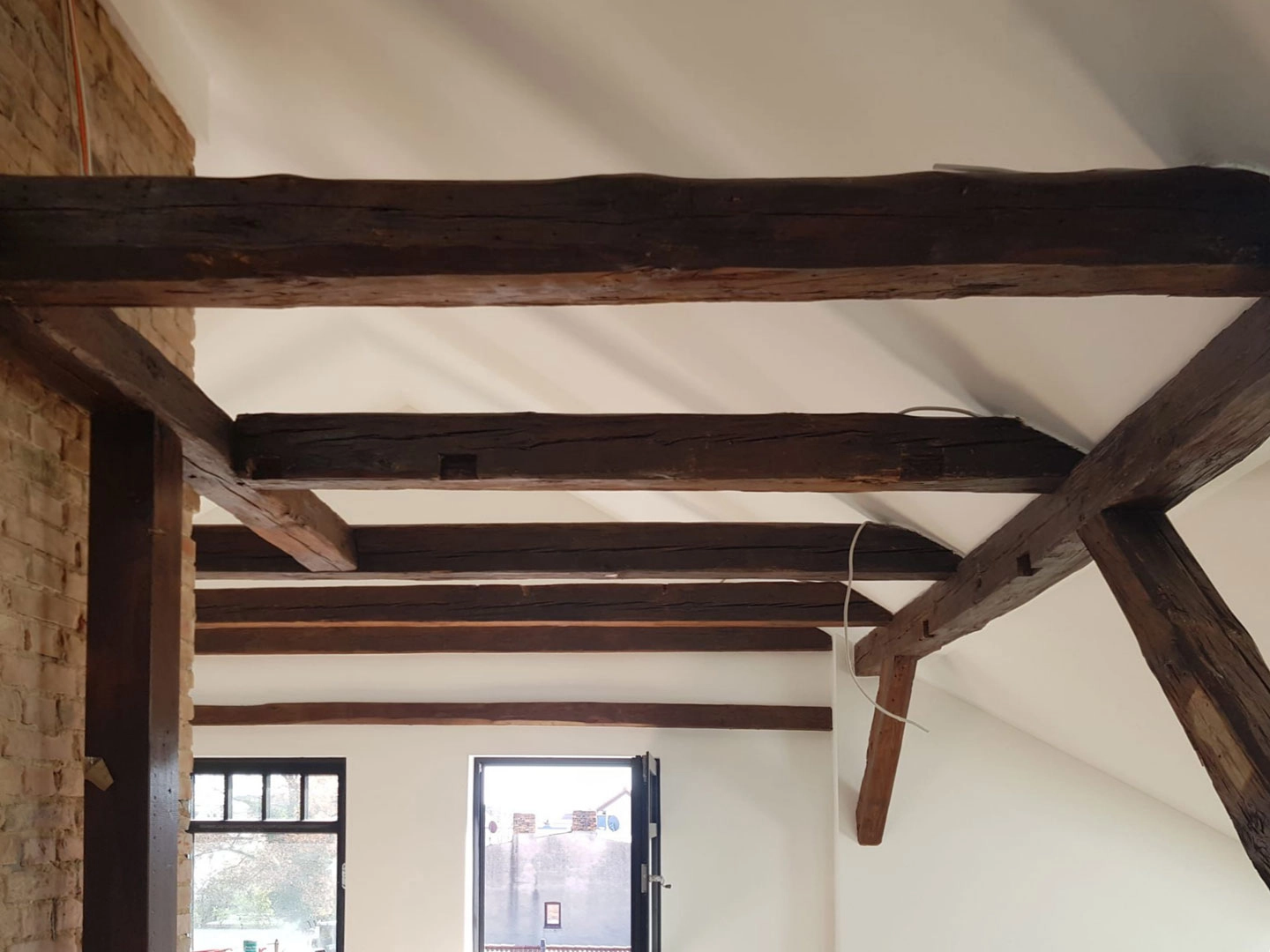 Ausgebautes Dachgeschoss Loft in Altbau mit sanierten Holzbalken und neuen Fenstern.