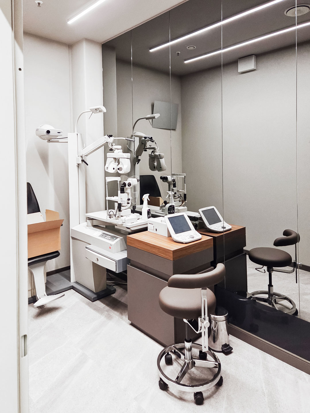 Moderner Refraktionsraum nach Ladenumbau beim Augenoptiker mit Messgeräten zur Bestimmung der Sehstärke.